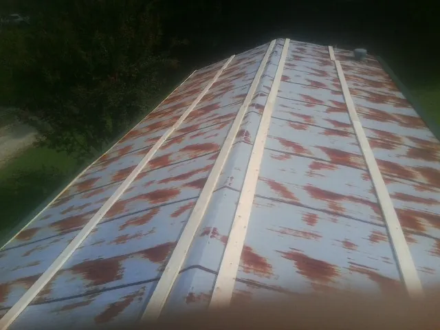 Rusted metal roof panels with new wood purlins before replacement — Storm Damage Roof Repair in Pierson by Roofing Brothers