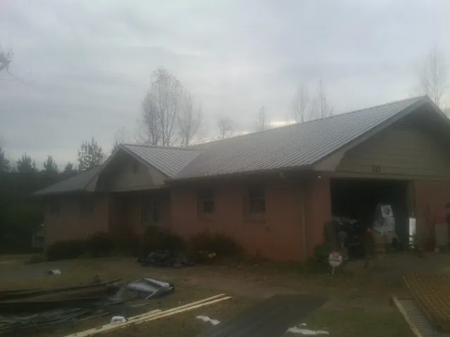 Gray metal roof on a stucco house with an attached garage in Pierson