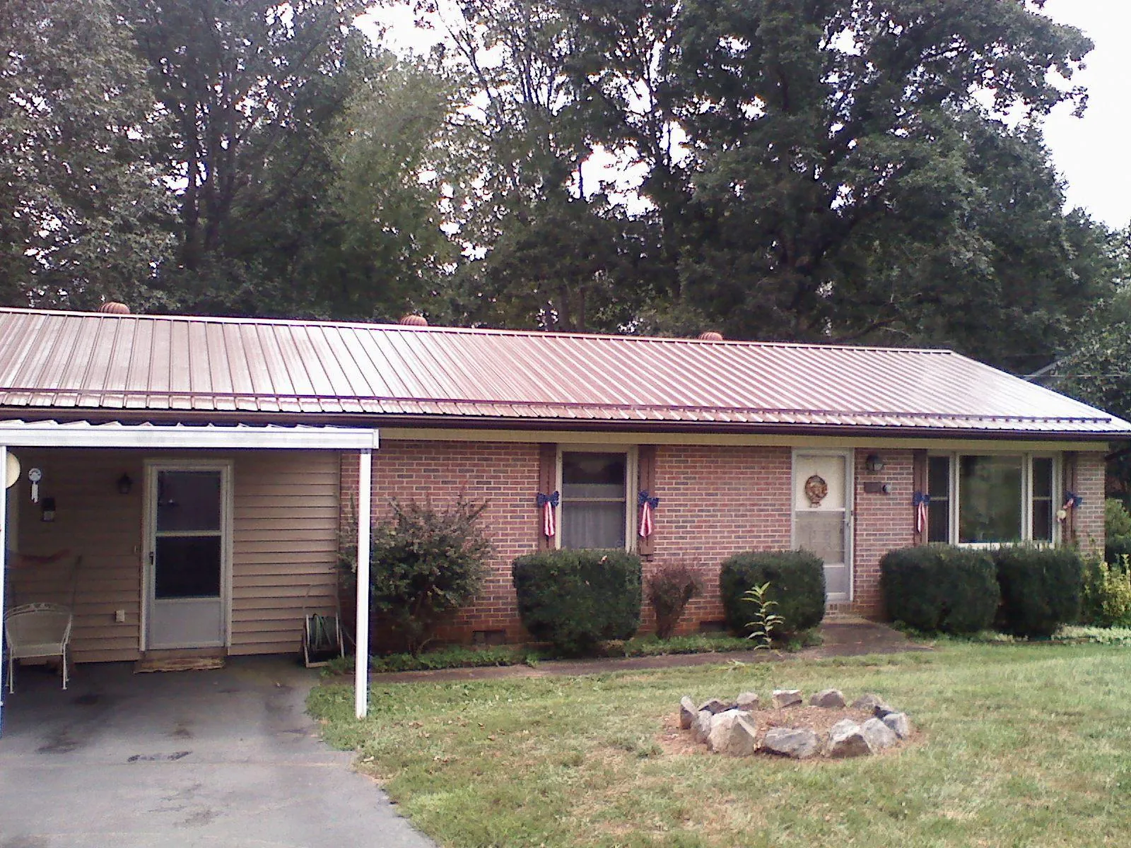 Bronze metal roof and carport on a brick ranch home — Roof Repair work by our crew in Pierson